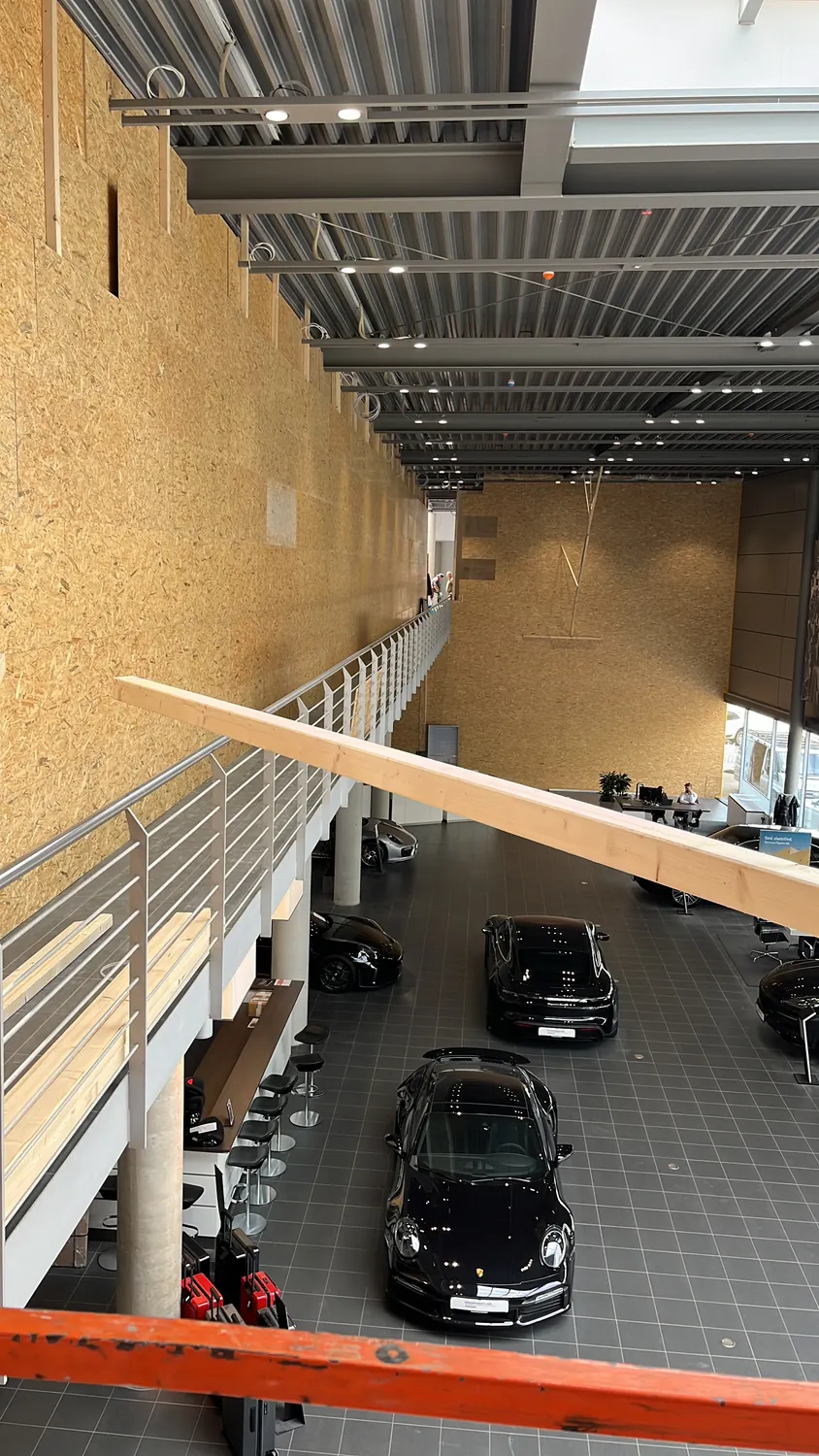 Blick von der Ebene in den Showroom mit Fahrzeugen und der Holzwand