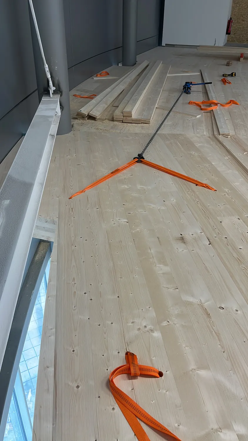 Verlegte Massivholzplatten der neuen Ebene mit Spanngurten