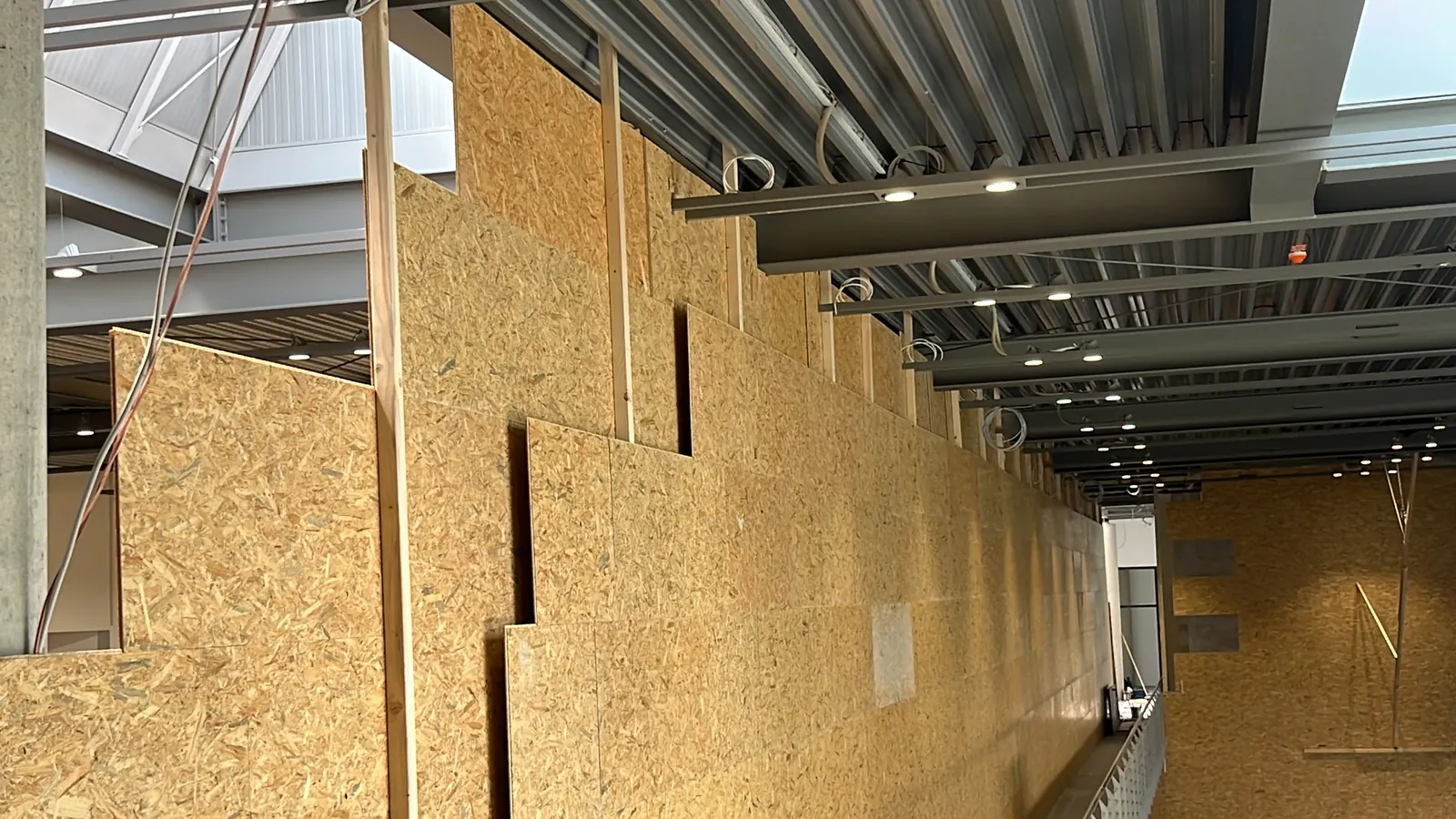 Raumhohe, temporäre Wandkonstruktion aus Holz und OSB-Platten im Showroom des Autohauses
